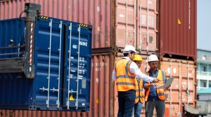 Harbor workers working next to containers