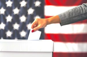 Woman Casting Ballot at Polling Place With American Flag in Background